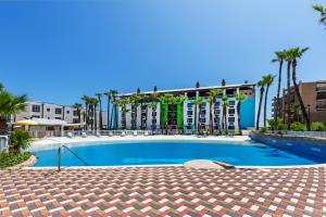 a swimming pool with palm trees in front of a building at Holiday Inn Resort South Padre Island-Beach Front by IHG in South Padre Island