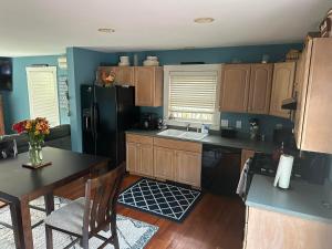 a kitchen with wooden cabinets and a black refrigerator at Sugar Hill Inn in Sugar Hill