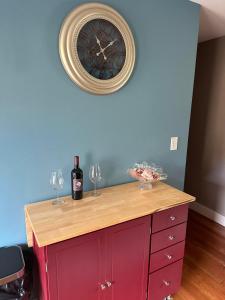 a red cabinet with wine glasses and a clock on the wall at Sugar Hill Inn in Sugar Hill