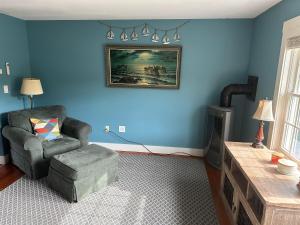 a living room with a chair and a painting on the wall at Sugar Hill Inn in Sugar Hill