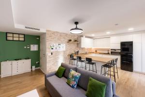 a living room and kitchen with a couch and a table at Jardinillos Bed & Parking in Jaén