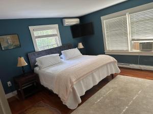 a bedroom with blue walls and a bed with white sheets at Sugar Hill Inn in Sugar Hill