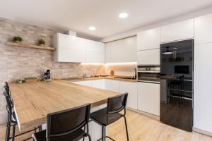 a kitchen with a wooden table and black appliances at Jardinillos Bed & Parking in Jaén