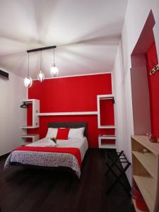 a red bedroom with a bed with a red headboard at B&B Scirocco D'Africa in Catania