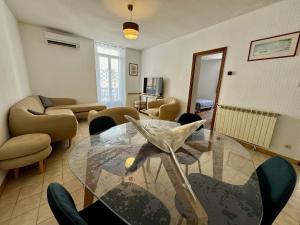 a living room with a glass table and chairs at Le balcon de Bandol in Bandol