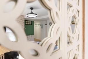 a mirror reflection of a living room in a room at Jardinillos Bed & Parking in Jaén