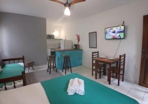 a living room with a table and chairs and a kitchen at Studio8 Centro Paraty in Paraty