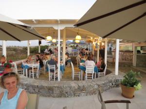 a group of people sitting at a restaurant at Blue Beach Villas Apartments in Stavros
