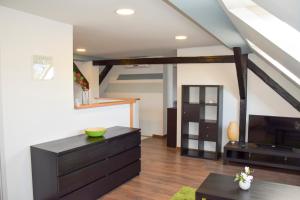 a living room with a black dresser and a tv at Nádor Apartman in Győr