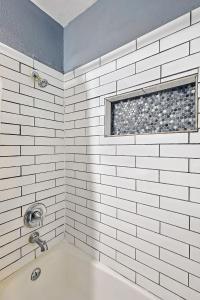 bagno bianco con vasca e finestra di Comfy and Modern Holiday Lofts in FW a Fort Worth Altre 5 foto