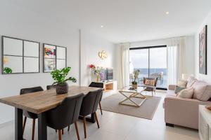 a living room with a table and chairs and a couch at Luxury penthouse with ocean views in Estepona