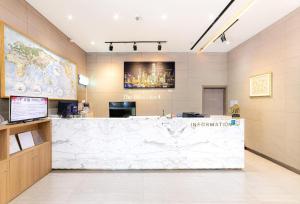 a lobby with a large white counter in a building at Benikea The Bliss Hotel in Incheon