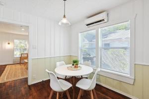 a dining room with a white table and white chairs at Comfy Holiday Loft 8min from Downtown FW in Fort Worth