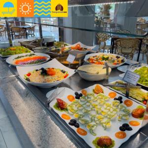 a buffet with many plates of food on a table at Spazzio DiRoma com acesso ao Acqua Park -Temporada CN Adriele in Caldas Novas +34 photos