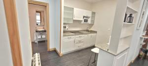 a small kitchen with white cabinets and a sink at Santana Apartment Metro in Las Arenas +8 photos