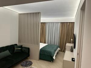 a small bedroom with a bed and a couch at Happy Studio Luxury Cortina North in Voluntari +11 photos