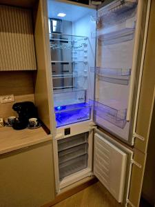 an empty refrigerator with its door open in a kitchen at Happy Studio Luxury Cortina North in Voluntari
