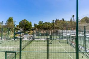 a tennis court with two tennis courts at Luxury penthouse with ocean views in Estepona