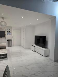 a living room with a flat screen tv on a white wall at Luxury and stylish 3 bedroom house or Apartment in Greenhithe - Available for booking as individual Room or as a Whole apartment - 11mins walk to Greenhithe Train Station, 7 mins drive to Bluewater shopping mall in Greenhithe