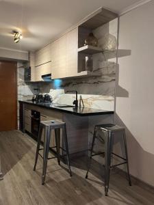 a kitchen with two bar stools and a counter at Roca Town House in Viña del Mar