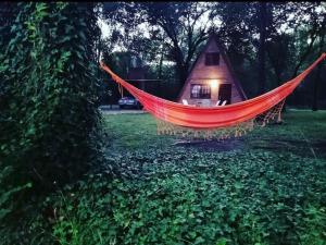 a red hammock in a yard with a house at Cabañas Valle Dorado in Villa Rumipal
