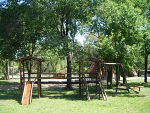 a playground with a swing set in a park at Cabañas Valle Dorado in Villa Rumipal