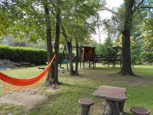 a playground with an orange hammock in a park at Cabañas Valle Dorado in Villa Rumipal