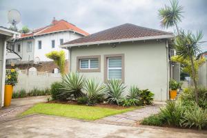 Una casa blanca con plantas delante de ella. en Beechwood B&B, en Durban
