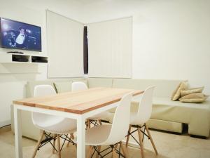 a dining room with a table and white chairs at Quadro Departamentos in Villa Carlos Paz