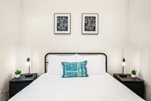 a white bed with a blue pillow on it at Serene Retreat Pool 2 Min to TCU in Fort Worth +18 photos