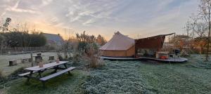 a tent in a yard with a picnic table at Au Pied Du Trieu, the glamping experience in Labroye