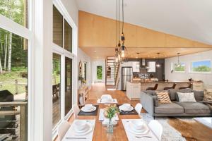 a living room and kitchen with a couch and a table at Chalet La Colline in Labelle +24 photos