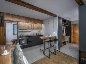 a kitchen with black cabinets and a table at Apartment Lana in Kranjska Gora