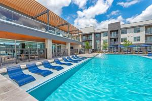 a swimming pool at a hotel with lounge chairs at Fascinating 2BD 2BA w Beautiful Pool in Fort Worth in Fort Worth