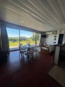 a dining room with a table and chairs and a large window at Casa FLORIDA in Villa Serrana