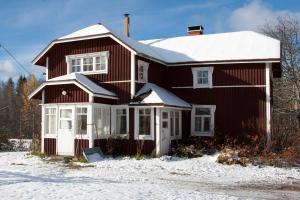 KalmariにあるLamminkangas Cottageの屋根に雪が積もった茶色の家