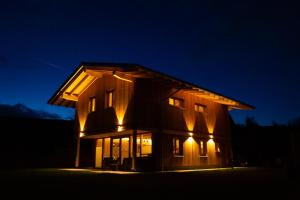 弗劳埃瑙Chalet Flanitzmühle的一座大型木屋,晚上有灯