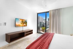 a bedroom with a large bed and a flat screen tv at FEISIVA LUXURY Apartament in Playa del Carmen