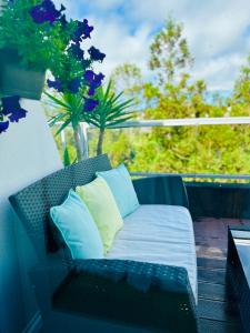 a bench on a balcony with blue pillows at Duplex Apartment Ponta Delgada in Fajã de Baixo
