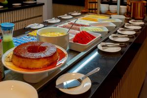a buffet line with a chocolate cake and other desserts at Hotel Roochelle Convention By Nobile in Curitiba