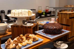 a table with a cake and some pastries on it at Hotel Roochelle Convention By Nobile in Curitiba +94 photos