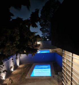 a swimming pool at night with lights on the ground at Quadro Departamentos in Villa Carlos Paz +12 photos