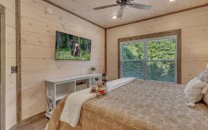une chambre avec un lit et une télévision au mur dans l'établissement Friendly Bear Plunge, à Pigeon Forge 38 autres photos