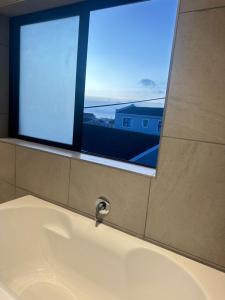 a bathroom with a bath tub with a window at DIE Huis House in Wilderness +24 photos