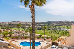 Blick auf eine Palme und einen Pool in der Unterkunft Ruime woning aan golfbaan in Rojales
