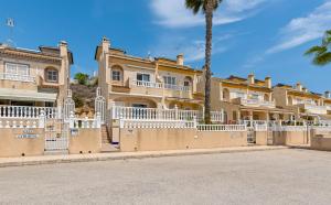 ein großes Haus mit weißen Zäunen und einer Palme in der Unterkunft Ruime woning aan golfbaan in Rojales