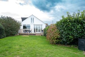a white house with a deck and a yard at Family & Pet-Friendly Seaside Bungalow with Accessible Features in Minster