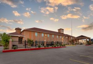 a building with a fence in front of a parking lot at Best Western Casino Inn in Vinton