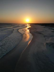 an aerial view of the beach at sunset at Apartamento em Arraial do Cabo- Vista Mar, Piscina e Churrasqueira Privativa na Varanda a 50 m da Praia in Arraial do Cabo