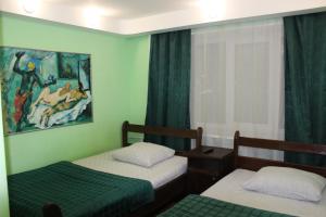 鄂木斯克的住宿－Aero Hotel，一间卧室设有两张床,墙上挂着一幅画